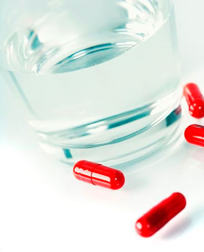 капсулы и стакан воды капсулы и стакан воды